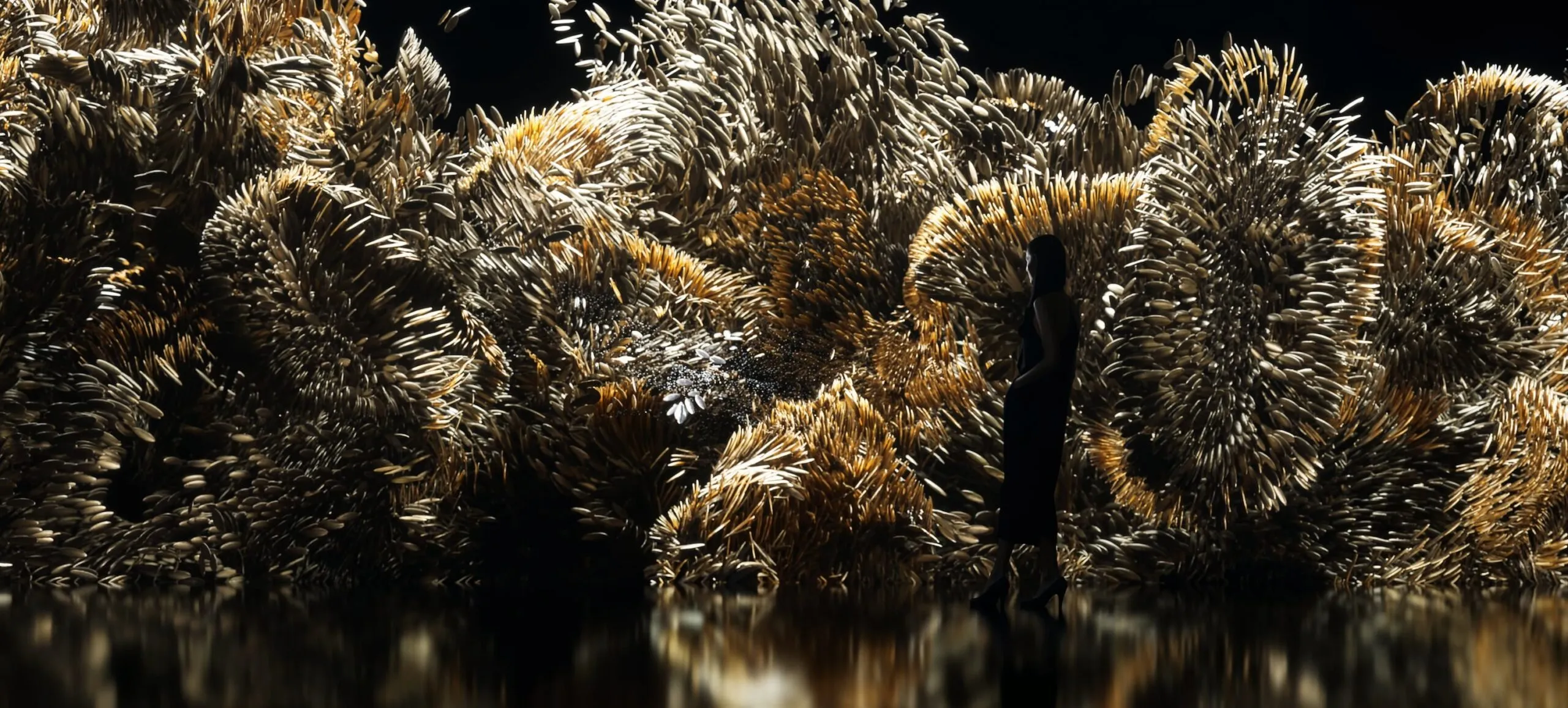 Detail of the performance imagery: golden metallic fibres twisting like living matter