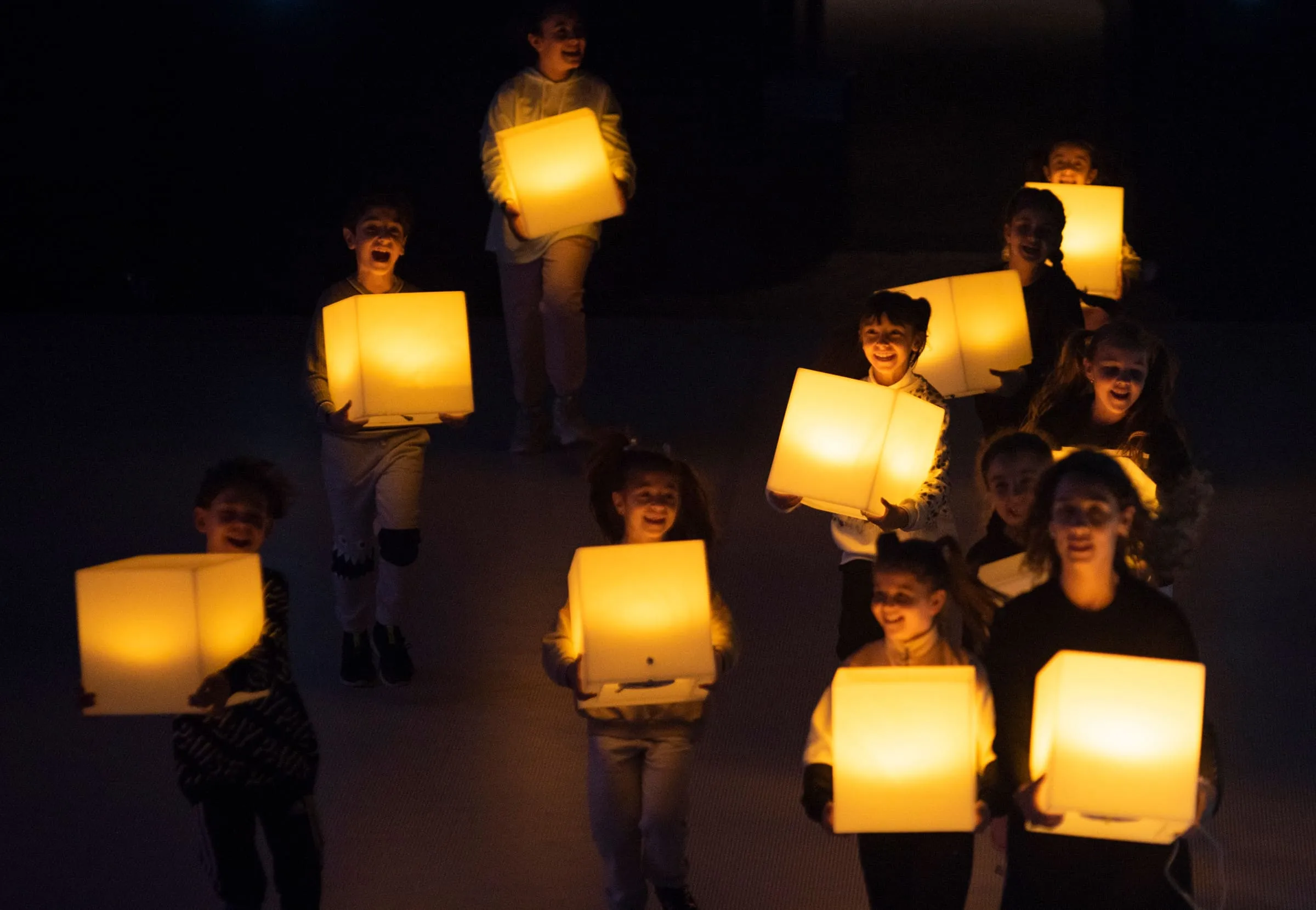 Children carrying glowing cubes of light through the dark