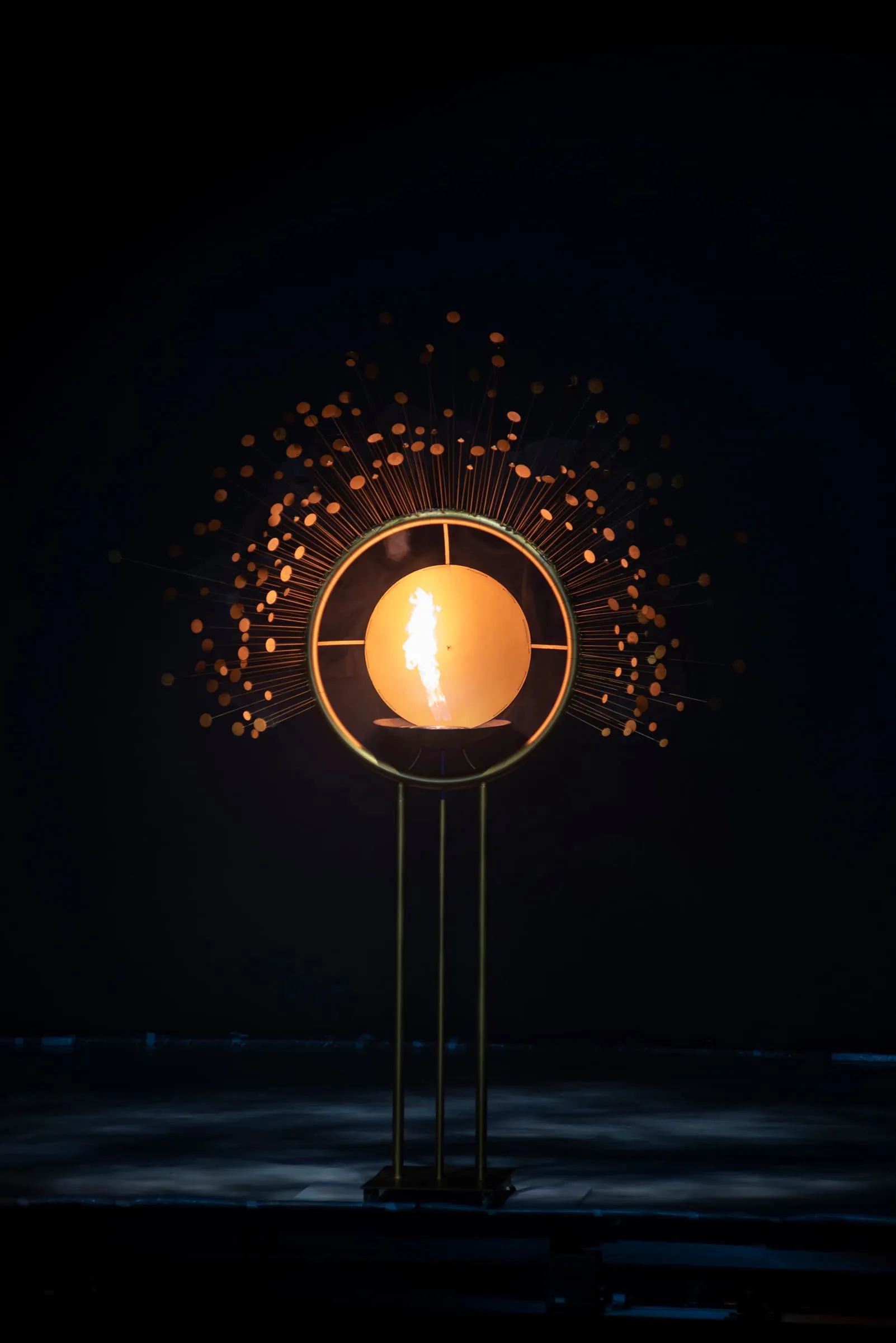 The fire sculpture: a ring with a single flame at its centre, haloed by points of light