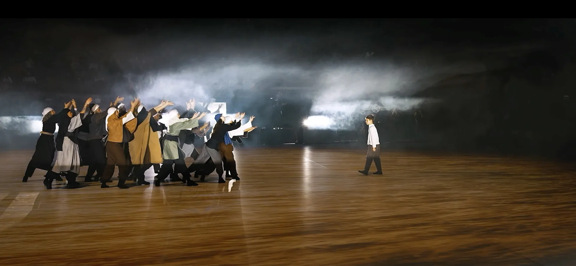 Dancers in early-republic costume on a projected floor, haze and light sweeping behind them