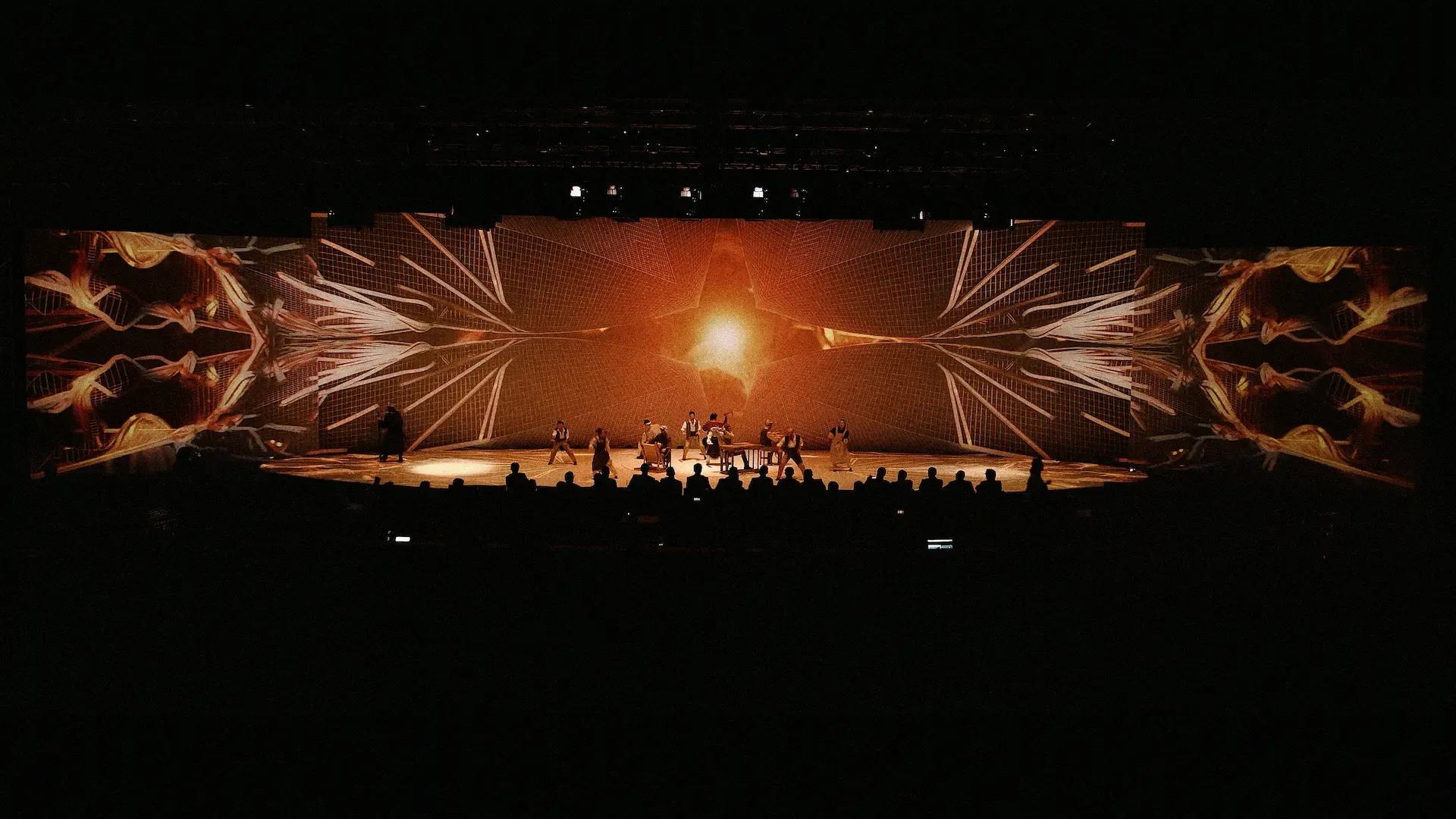 The ceremony stage with a radiant orange starburst projected across its full width