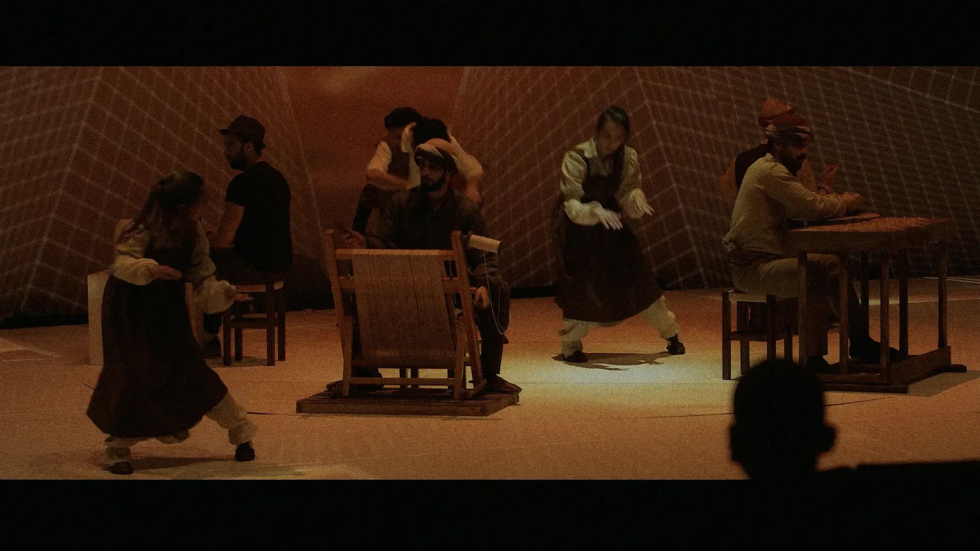 Actors in period costume around wooden tables, playing a scene from Türkiye's history
